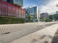 a city street with water spewing out from the sidewalk as well as building windows