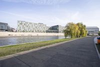 a large, rectangular building in the middle of a grassy area next to the water