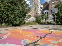 an old basketball court painted with colorful street art outside the city buildings in europe / europe