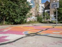 an old basketball court painted with colorful street art outside the city buildings in europe / europe