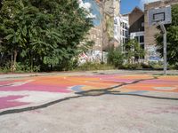 an old basketball court painted with colorful street art outside the city buildings in europe / europe