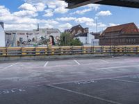 a bus stop with cars parked in front of a mural on the side of a building