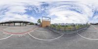 a very nice looking fisheye lens on a parking lot of some sort with buildings in the background