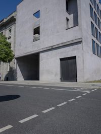 a man is riding a motorcycle in front of a building with a tree growing outside the building