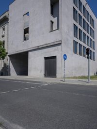 a man is riding a motorcycle in front of a building with a tree growing outside the building