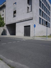 a man is riding a motorcycle in front of a building with a tree growing outside the building