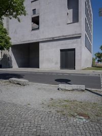 a man is riding a motorcycle in front of a building with a tree growing outside the building