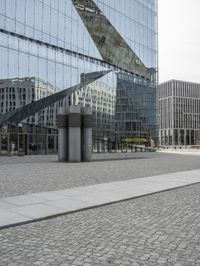 there is a large mirror on the side of this building with a small bench in the foreground