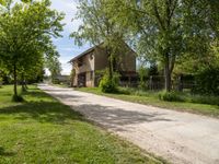 an image of an old country road through the country side of the country side, with buildings in the background