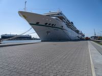 the large white cruise ship has a huge bow and a green stripe on it's side