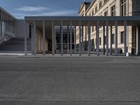 an empty street in front of a building in the day time as seen from the front with a bicycle