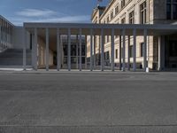 an empty street in front of a building in the day time as seen from the front with a bicycle