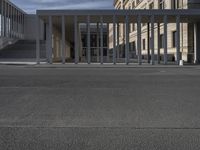 an empty street in front of a building in the day time as seen from the front with a bicycle