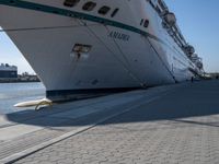 a person stands near a dock with the ship in the background on a sunny day