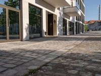 a large glass window in a building with a brick sidewalk next to it and a city street