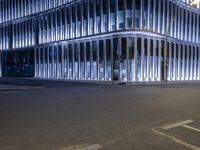 the building is surrounded by glass and steel panels that create an arch for it to sit on