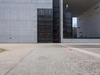 there is a red fire hydrant in front of a gray building with a gate