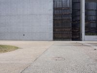 there is a red fire hydrant in front of a gray building with a gate