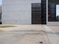 there is a red fire hydrant in front of a gray building with a gate