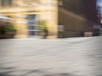 the view from a perspective of a man riding a skateboard on the street, using a blurry image