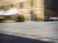 the view from a perspective of a man riding a skateboard on the street, using a blurry image