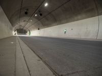 there is a man standing in the middle of a tunnel that looks like it has a car going through