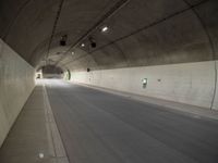 there is a man standing in the middle of a tunnel that looks like it has a car going through