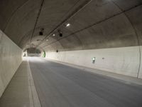 there is a man standing in the middle of a tunnel that looks like it has a car going through