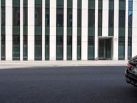 a black skateboard is standing in the middle of the street in front of a building