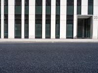 a black skateboard is standing in the middle of the street in front of a building