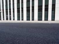 a black skateboard is standing in the middle of the street in front of a building