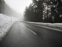a cold, foggy road on a gloom morning in wintertime with a single skiboard