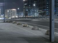 the empty city road is empty by the tall building in the background at night with light streaking on the buildings