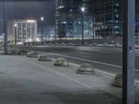 the empty city road is empty by the tall building in the background at night with light streaking on the buildings