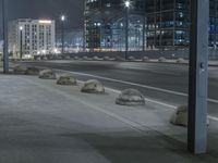 the empty city road is empty by the tall building in the background at night with light streaking on the buildings