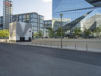 a long road leads into the center of a city and has glass buildings behind it