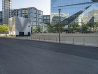 a long road leads into the center of a city and has glass buildings behind it