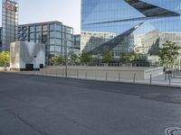 a long road leads into the center of a city and has glass buildings behind it