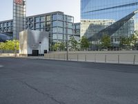 a long road leads into the center of a city and has glass buildings behind it