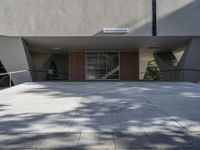 an entrance of a building that has glass doors and a bench in the front of it