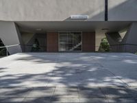 an entrance of a building that has glass doors and a bench in the front of it