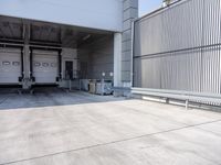 empty parking garage in urban building near building and sidewalk with storage bins on the side