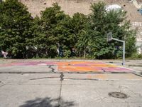 the old basketball court has a few painted markings on it, as well as a brick building