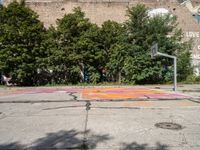 the old basketball court has a few painted markings on it, as well as a brick building