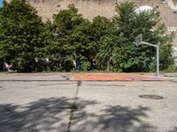 the old basketball court has a few painted markings on it, as well as a brick building