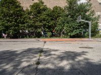 the old basketball court has a few painted markings on it, as well as a brick building