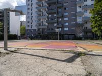 an empty basketball court is painted on a city street in bright colors with graffiti on the ground and walls