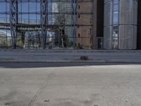 a boy is playing with a soccer ball in front of a building with a reflection of a tree