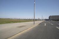 a white truck driving down the highway beside an empty parking lot below an overpass