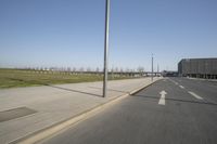 a white truck driving down the highway beside an empty parking lot below an overpass